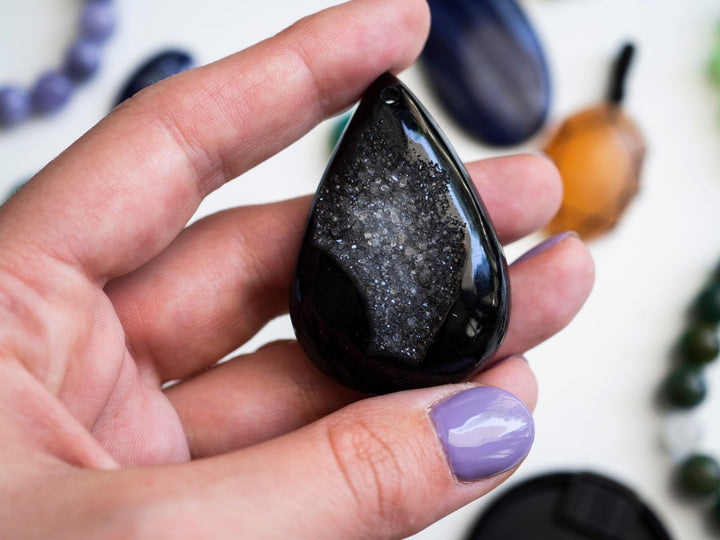 Black agate crystal in a woman’s hand.